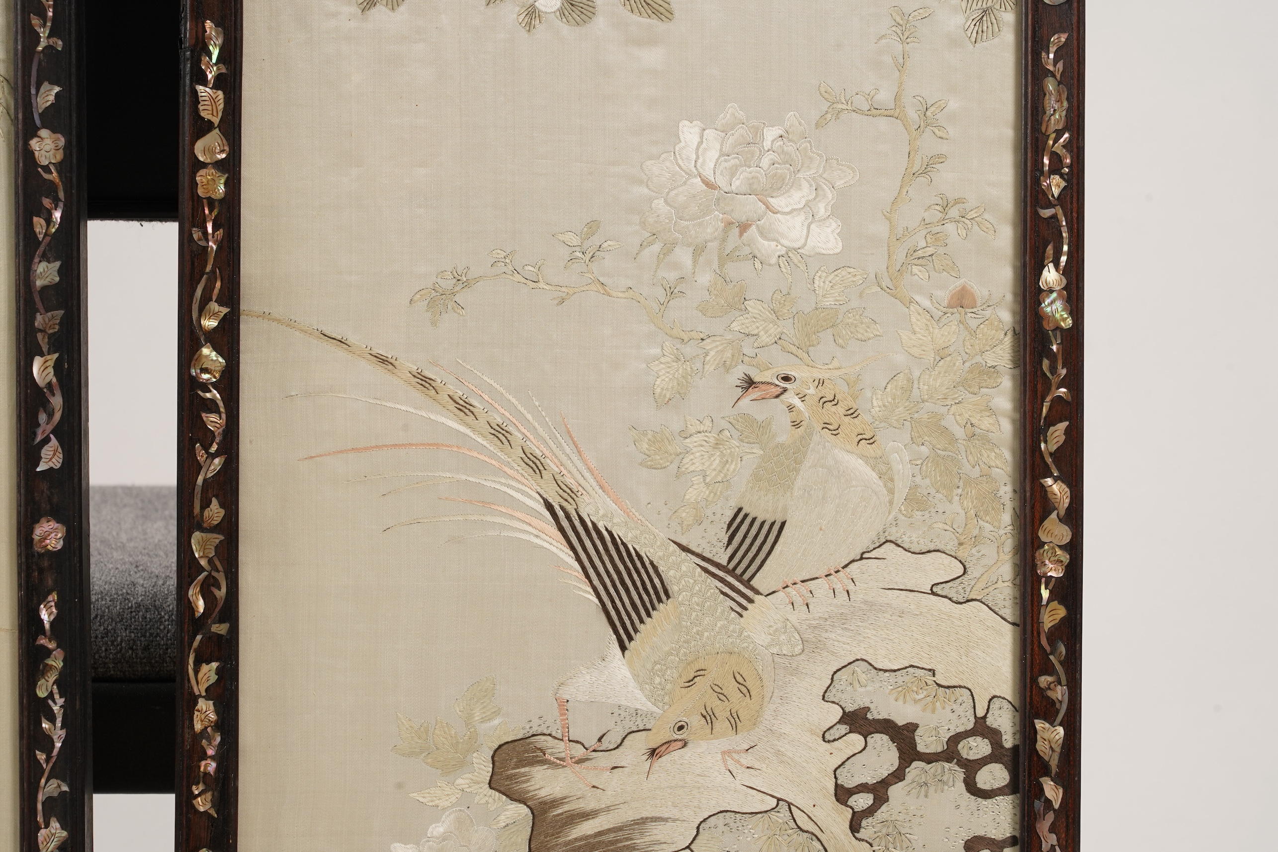 A pair of Chinese embroidered silk ‘bird’ panels, in mother-of-pearl inlaid hongmu frames, late 19th/early 20th century